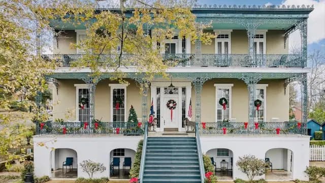 A classic two-story home adorned with festive wreaths and red decorations.