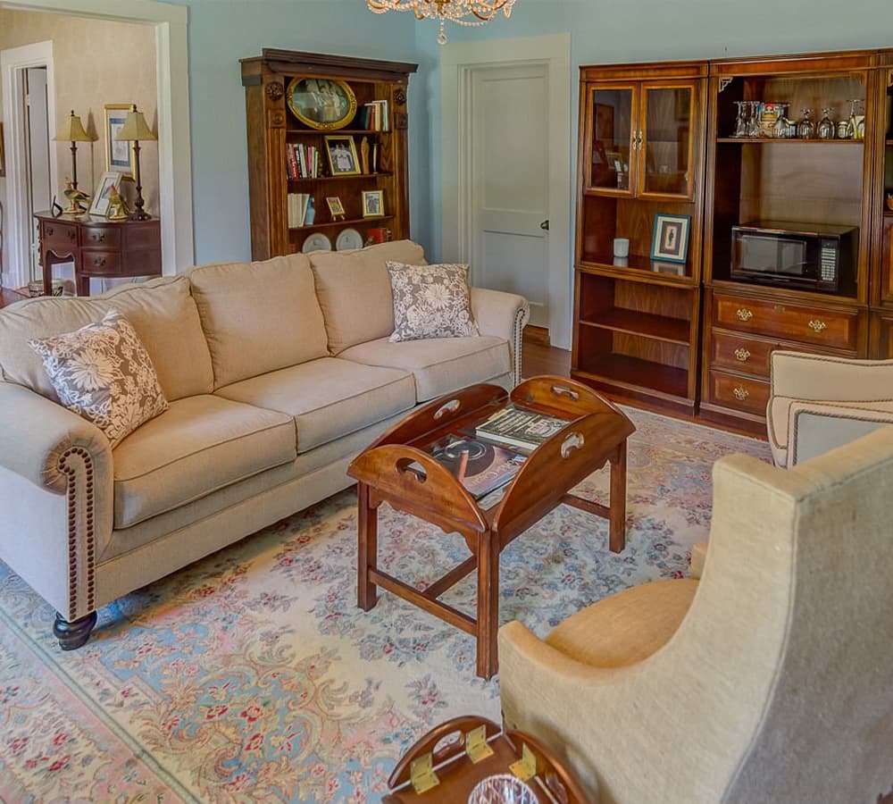 A cozy living room featuring a beige sofa, wooden coffee table, and decorative shelves.